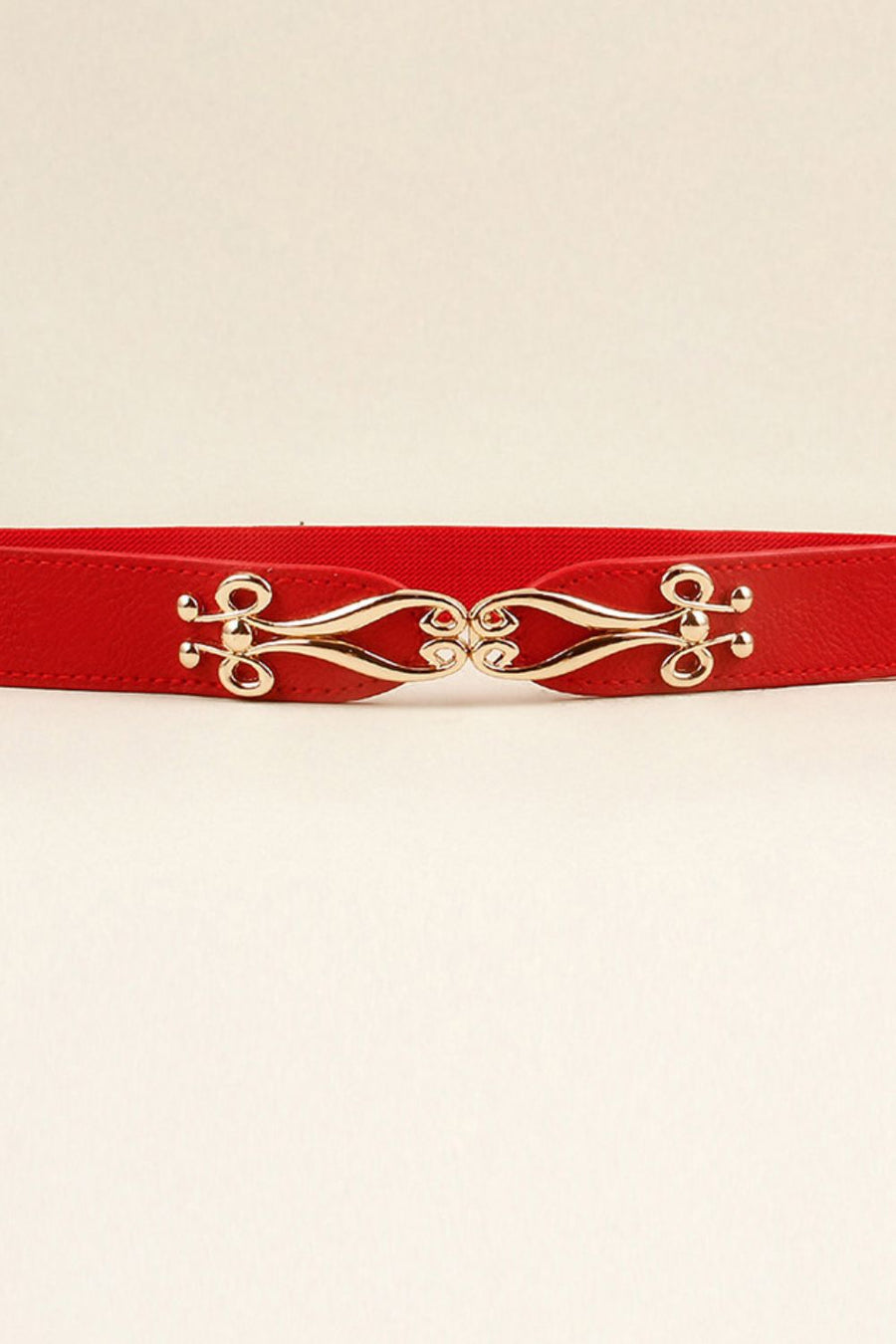 Red elastic belt with ornate gold clasp and faux leather trim