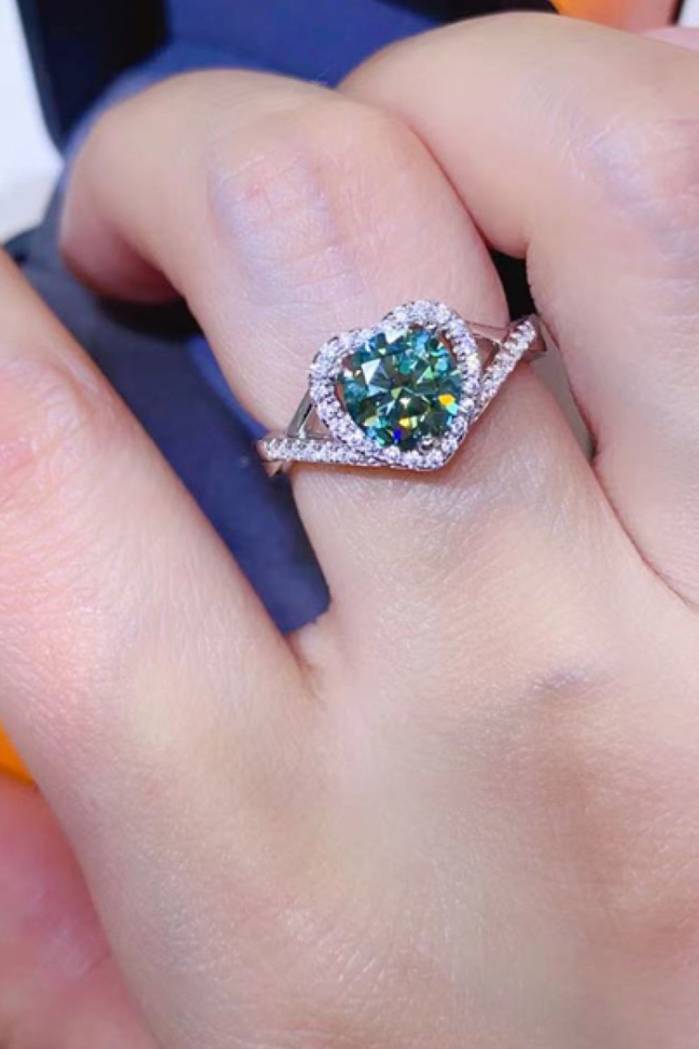 Green heart halo moissanite engagement ring in silver with pave band.