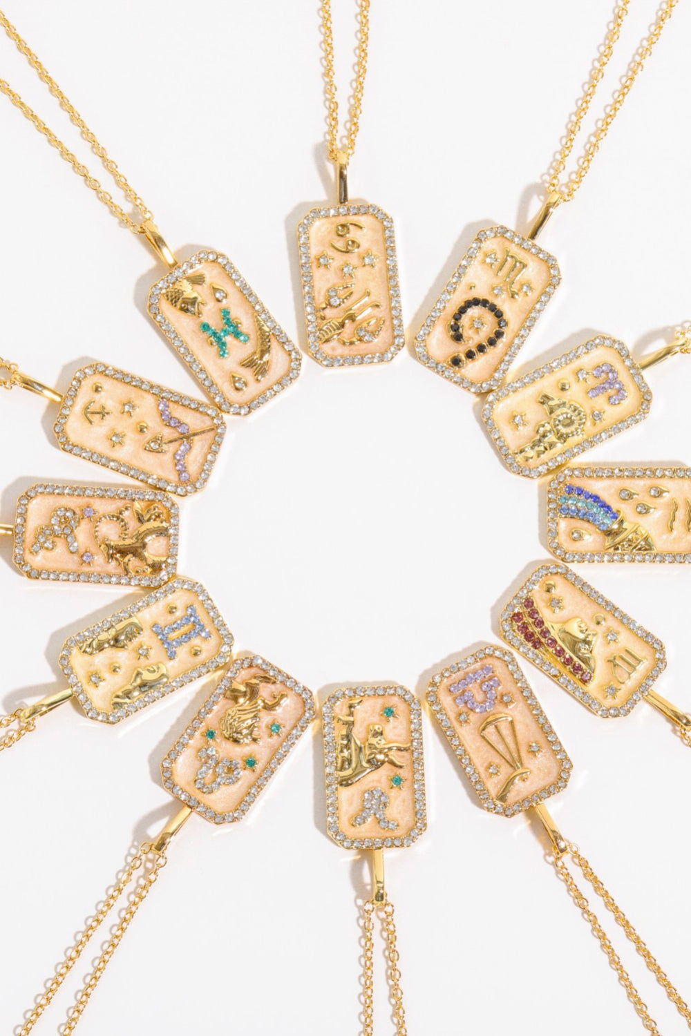 Zodiac sign crystal pendant necklaces in 14K gold-plated metal with gemstone accents.