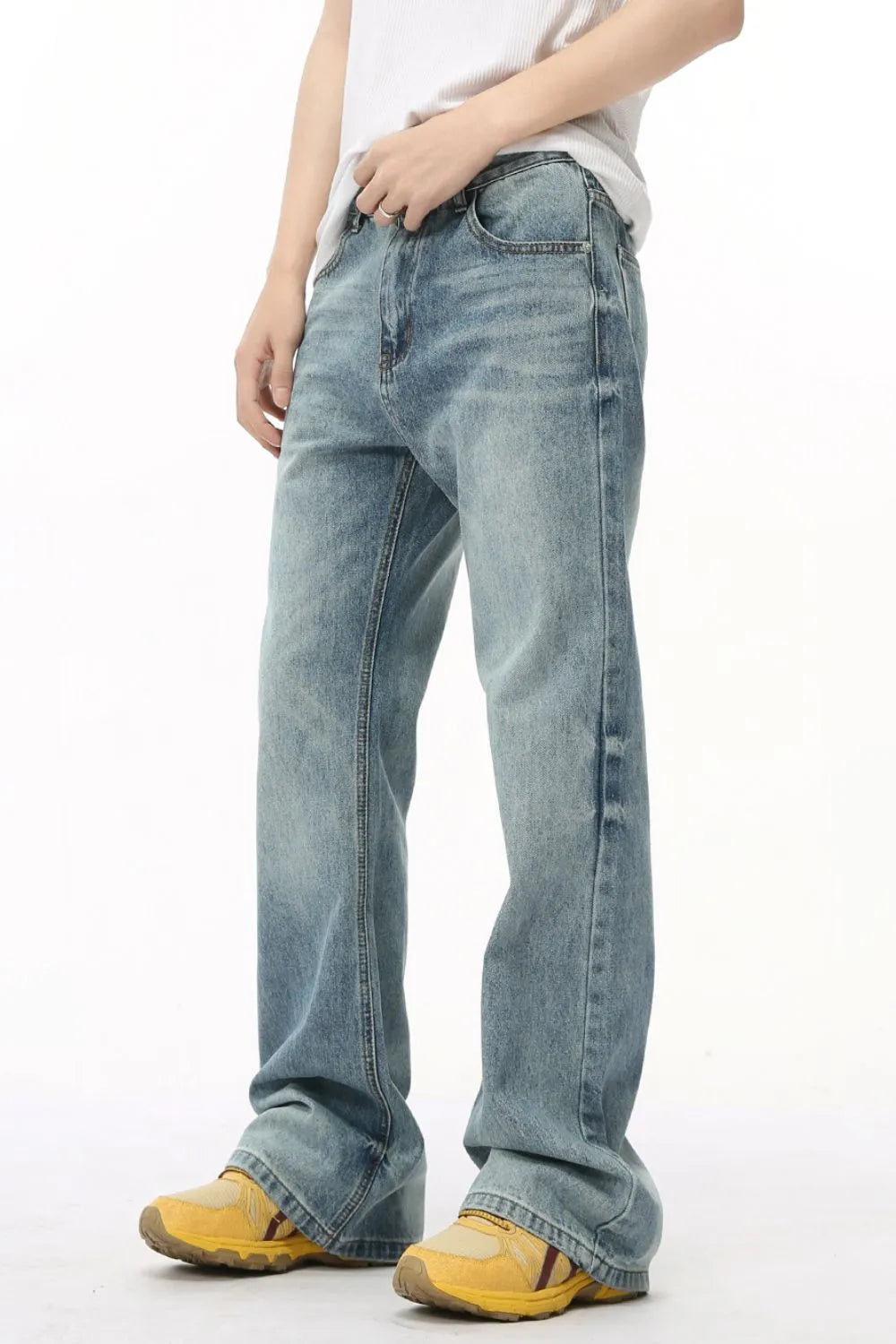 Wide leg denim bell bottoms in medium wash, styled with yellow sneakers.