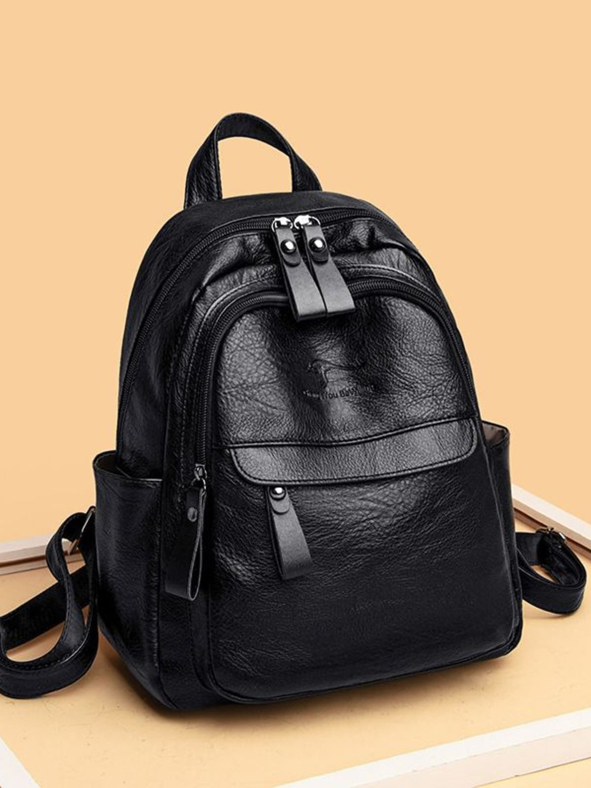 Black pu leather medium backpack with multiple compartments and zippered pockets.