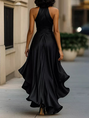 Black halter maxi dress with ruffled asymmetrical hem and belted waist.