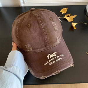 Brown distressed baseball cap with white embroidered text and frayed details