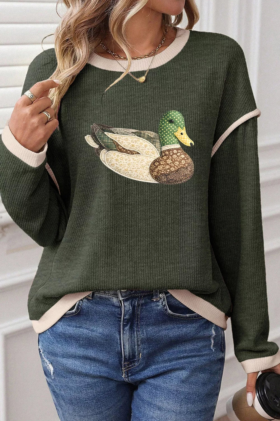 cream pullover sweater featuring contrast trim and graphic print