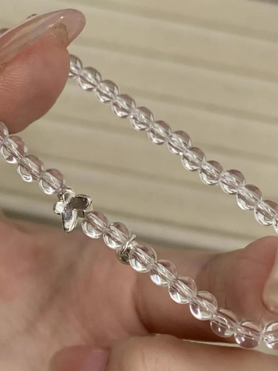 Clear crystal bead bracelet with a silver butterfly charm.