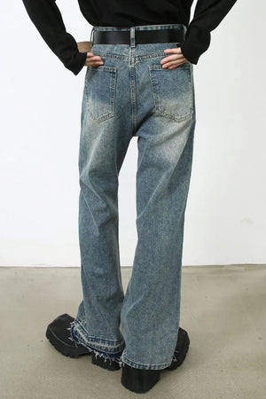 Distressed wide-leg denim jeans in medium wash with raw hem detail.