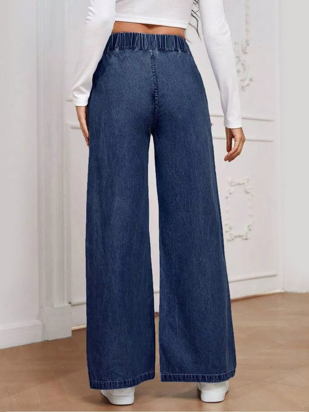 Dark blue high-waisted wide leg jeans with elastic waistband and full length.