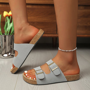 Gray buckle strap open toe sandals with cork sole and gold buckles.