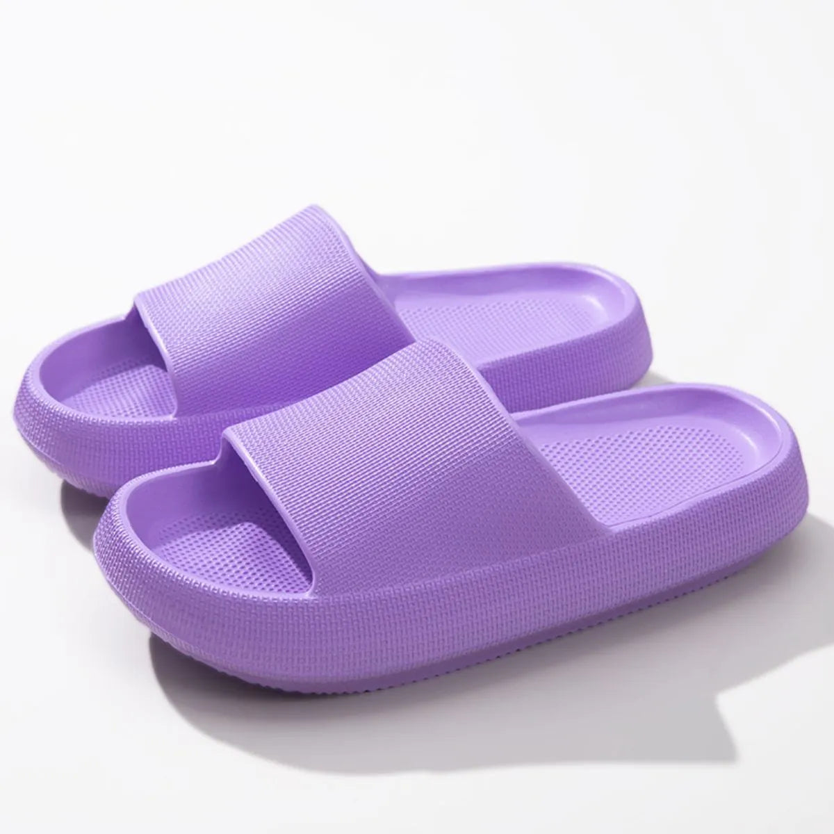 Textured cloud slides slippers in purple with thick soles and ribbed straps.