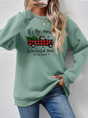 Sage green sweatshirt with plaid truck and Christmas tree graphic.