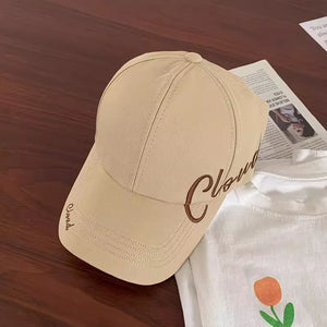 Beige baseball cap with embroidered "Cloud" detail, cotton material, curved brim.