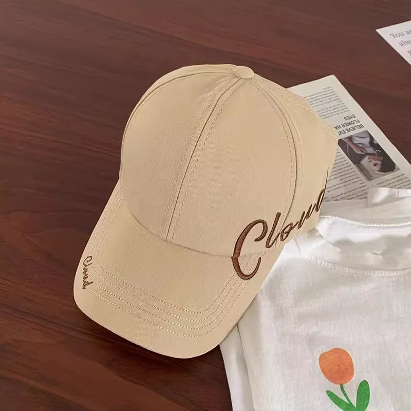 Beige baseball cap with embroidered "Cloud" detail, cotton material, curved brim.