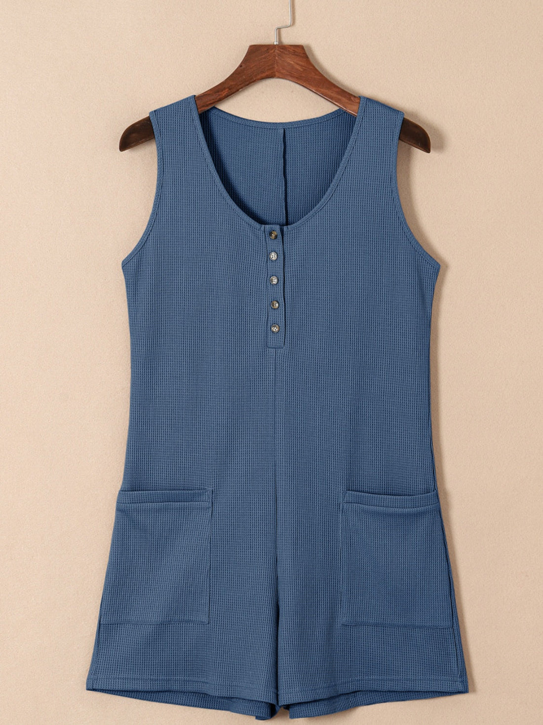 Dusty Blue waffle knit button-down romper with pockets and a scoop neckline.