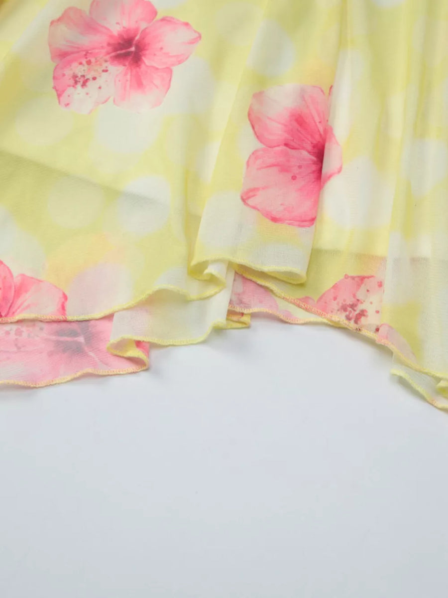 Yellow floral asymmetrical mini dress with ruffled hem and polka dot detail.