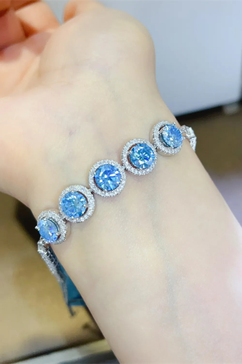 Blue moissanite and diamond halo bracelet in silver.