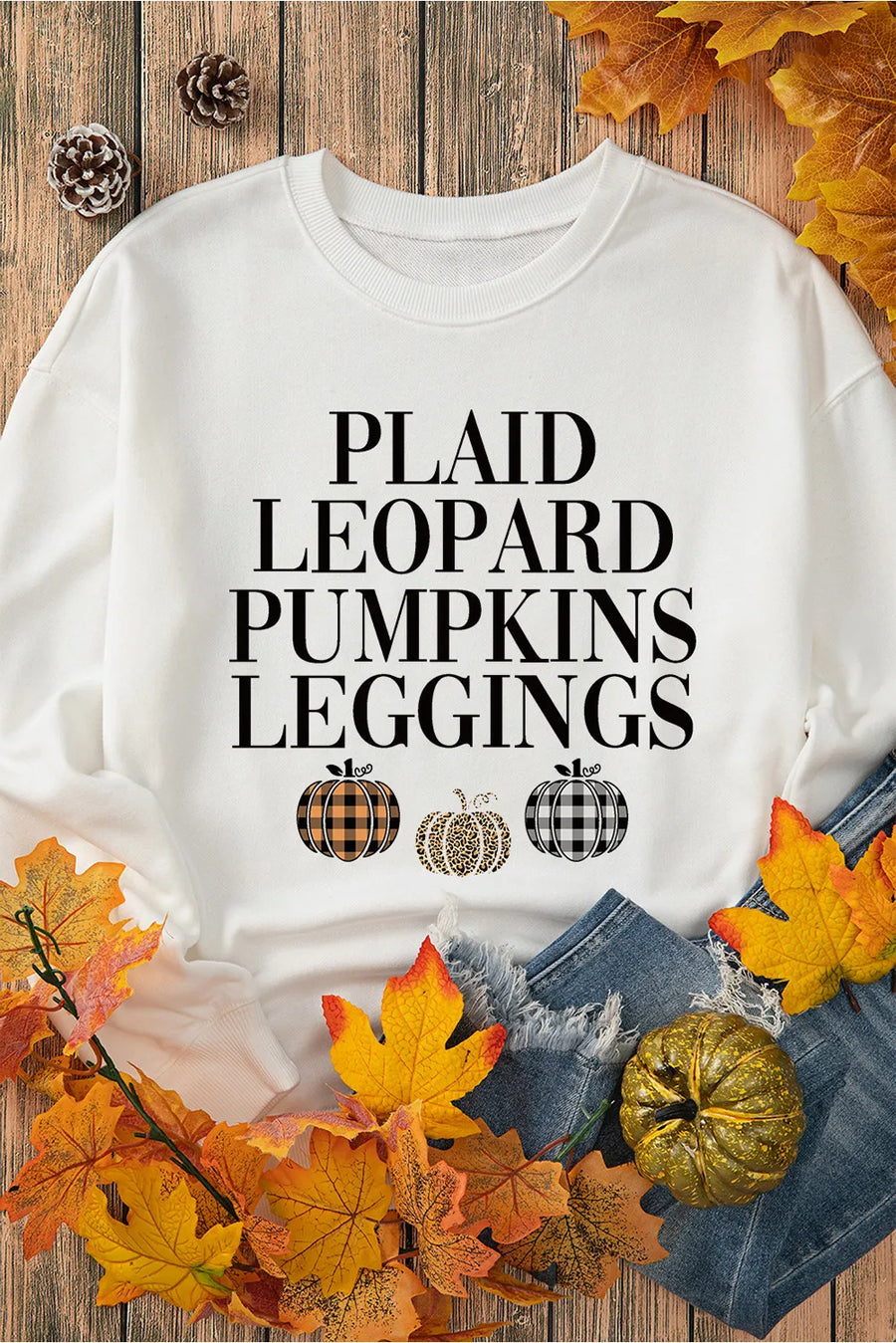 White round neck sweatshirt with text and three pumpkins: plaid, leopard, and buffalo check patterns.