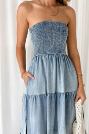 Light blue denim strapless tiered maxi dress with smocked bodice and pockets.