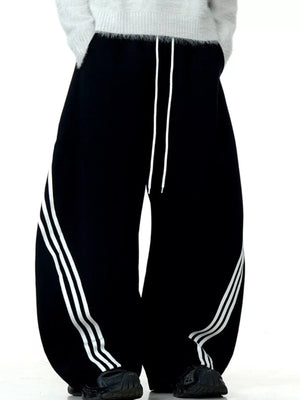 Men's black wide-leg sweatpants with white side stripes and drawstring waist.