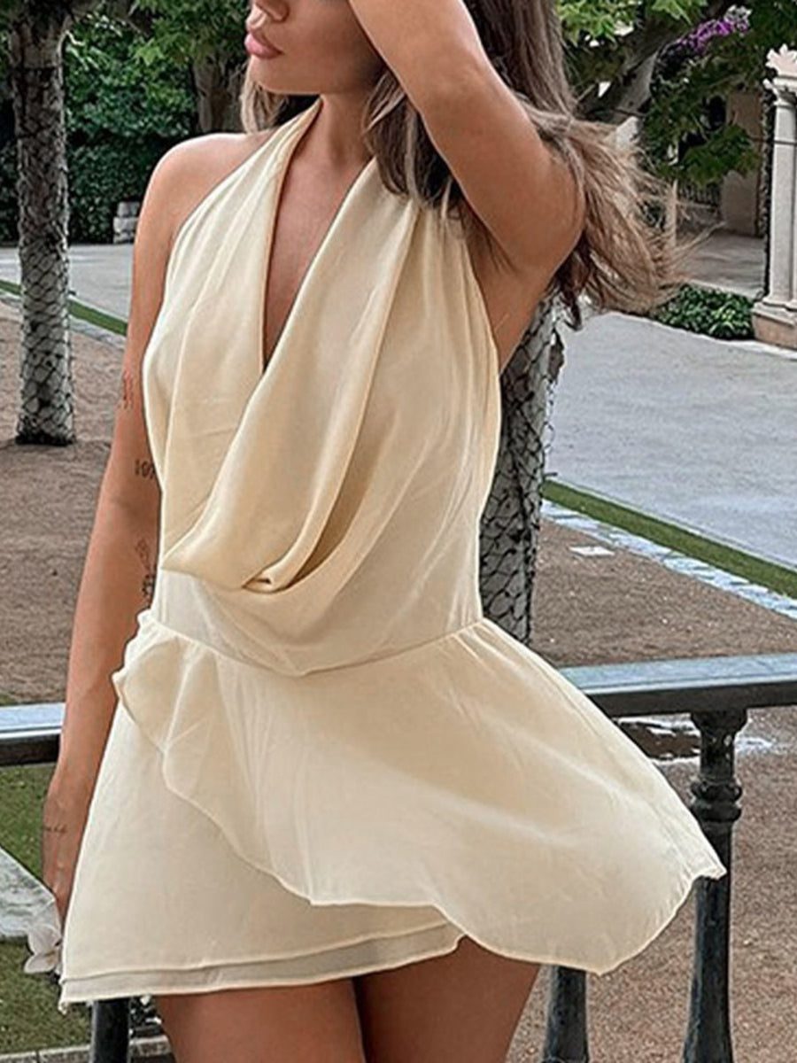 Backless ruffled mini dress in cream with a cowl neck and asymmetrical hem.