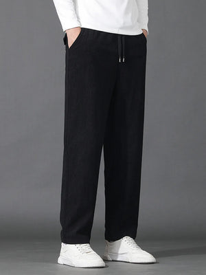 Black sweatpants with drawstring waist and pockets, styled with white sneakers.