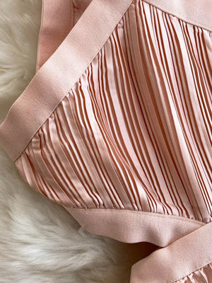 Pink pleated maxi dress with cutout detail and elastic trim.