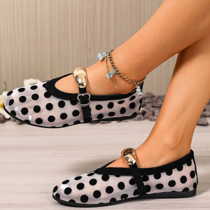 Black polka dot mesh slip-on flats with adjustable strap and gold buckle detail.