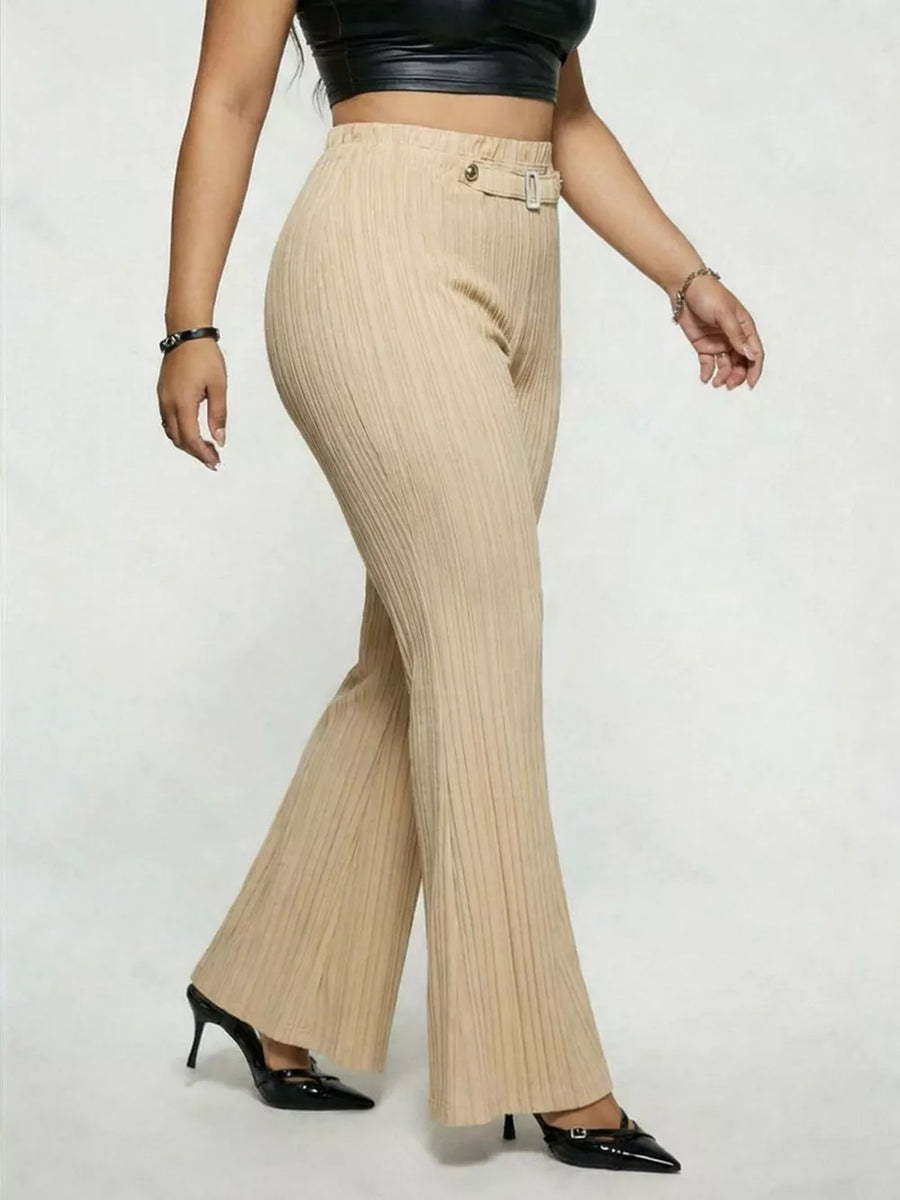 Ribbed high-waist flare trousers in caramel with buckle detail, styled with heels.