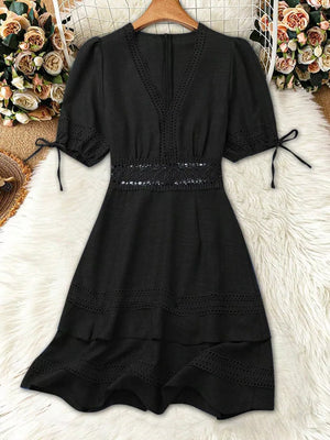 Black lace-embellished V-neck mini dress with tie-sleeve detail and tiered hem.