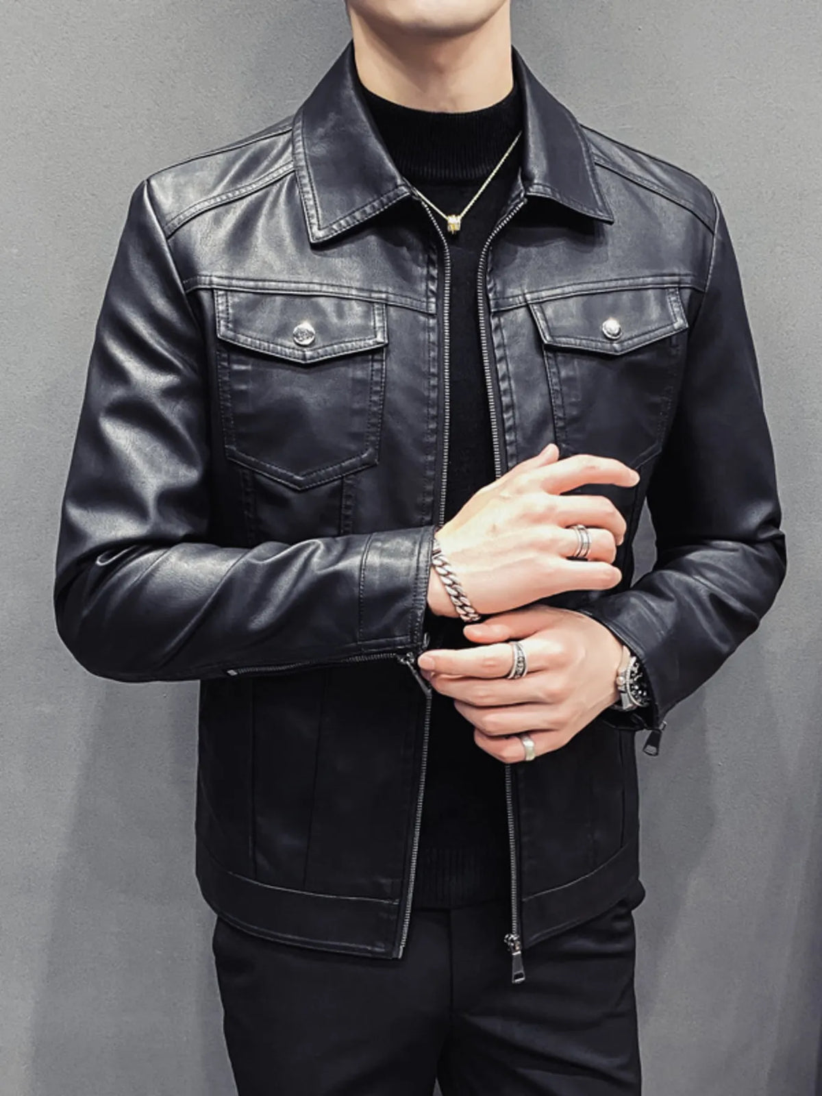 Men's black faux leather trucker jacket with chest pockets and zip closure.