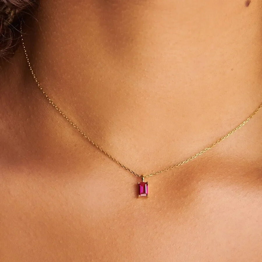 Prism cut gemstone necklace in 18K gold with a vibrant pink rectangular gem.