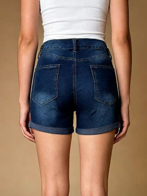Dark blue cuffed denim shorts with distressed details and button closure.