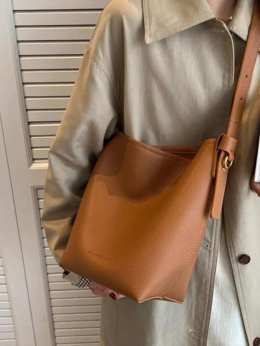 Brown minimalist PU leather shoulder bag with adjustable strap and gold buckle detail.