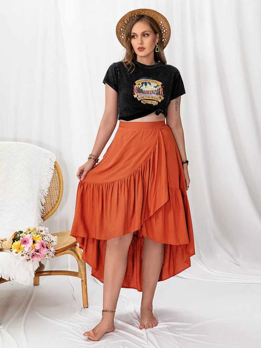 Orange ruched high-low wrap skirt with ruffled hem, styled with a graphic tee.