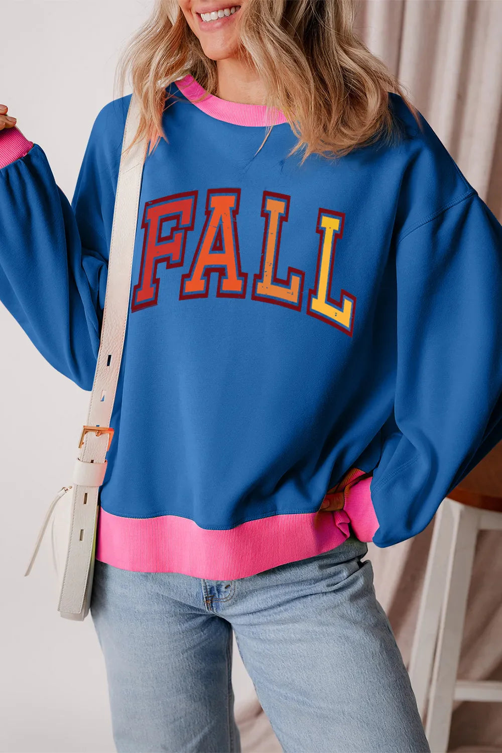 Peacock blue sweatshirt with pink trim and "FALL" graphic, casual fall style