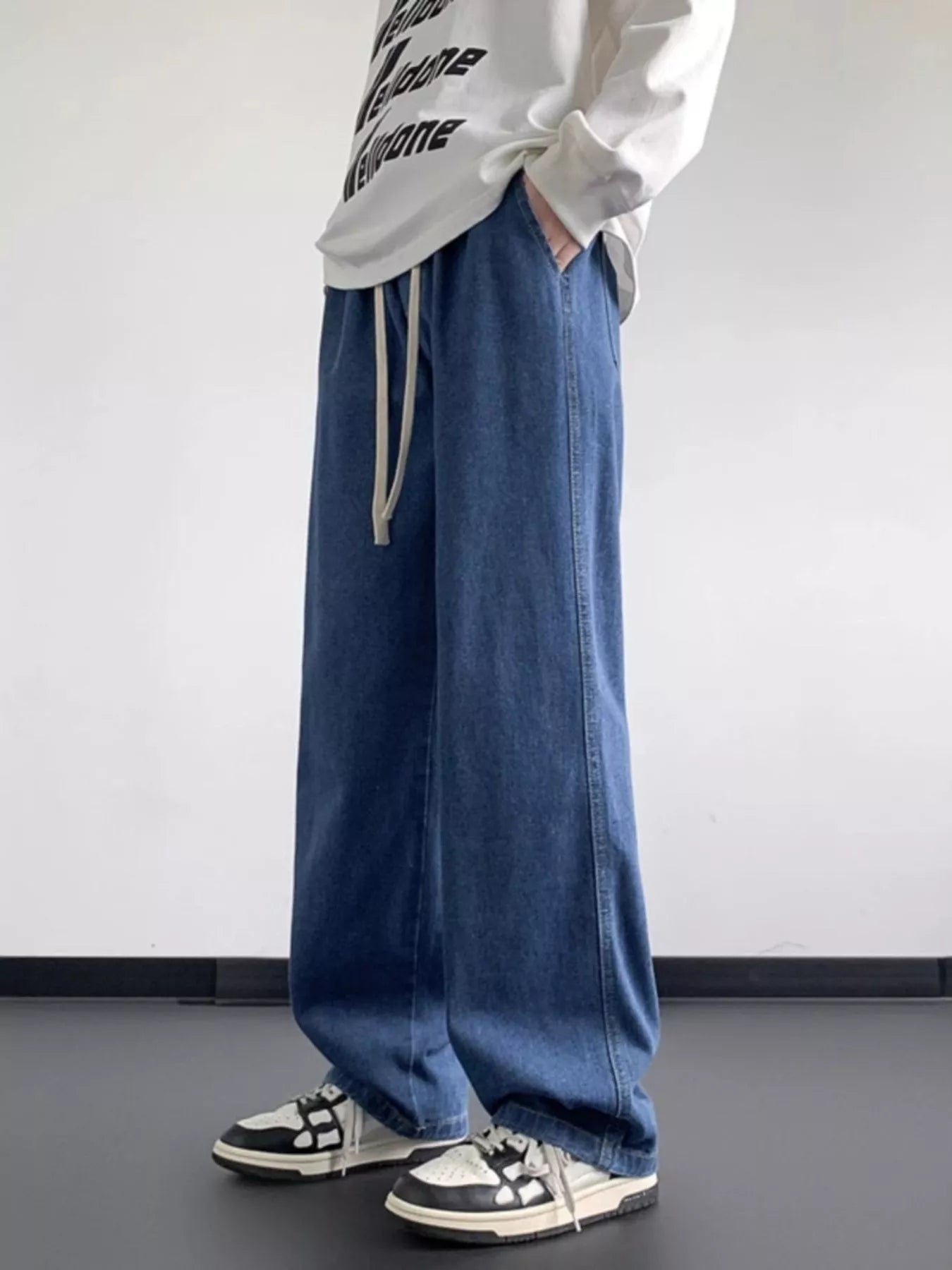 Oversized drawstring jeans in light blue denim with a loose fit and casual styling.