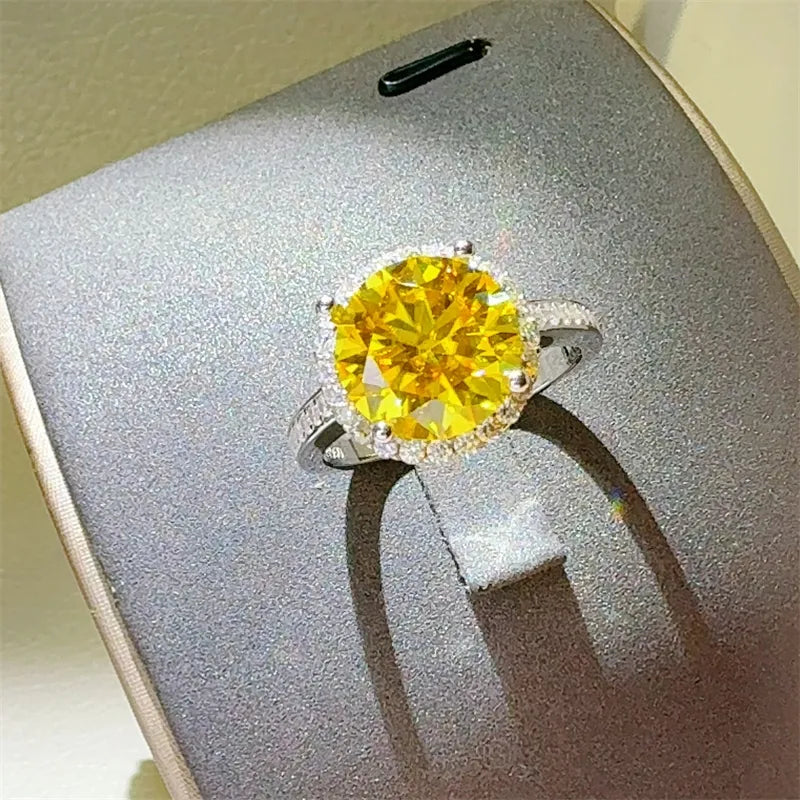 Sterling silver ring with large yellow moissanite center stone and halo of small stones.