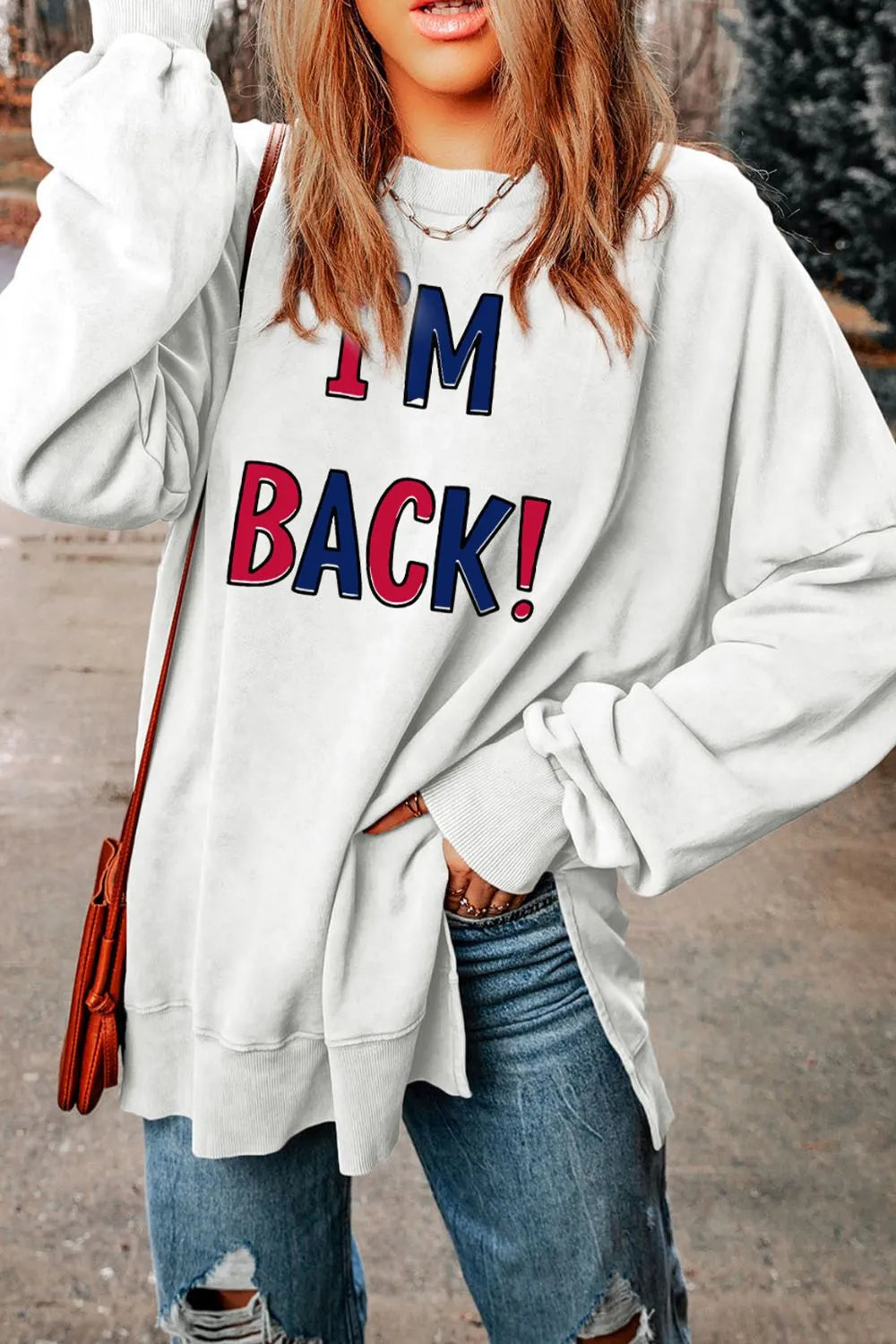 White graphic sweatshirt with I'M BACK! text and slit hem