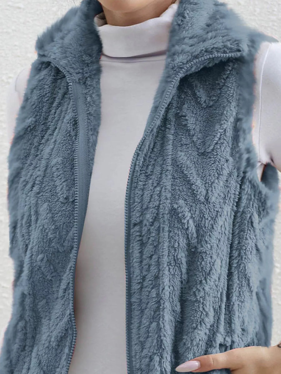 Blue faux fur zip-up vest with a textured pattern and stand-up collar.