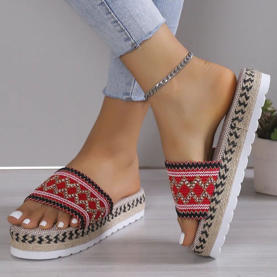 Embroidered platform espadrille slides in red with woven jute sole and white pedicure.