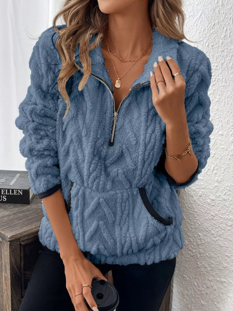 Blue sherpa half zip sweatshirt with textured pattern and front pocket.