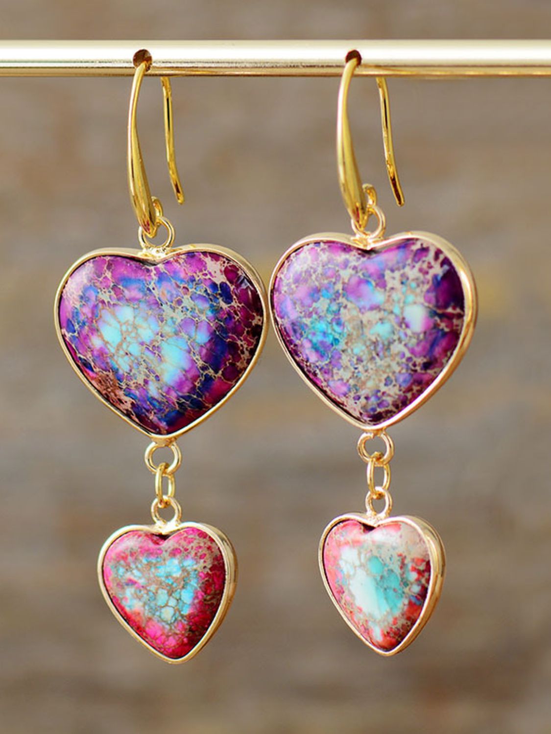 Heart stone cascade earrings in electric purple with gold-tone hooks and dangling heart charms.