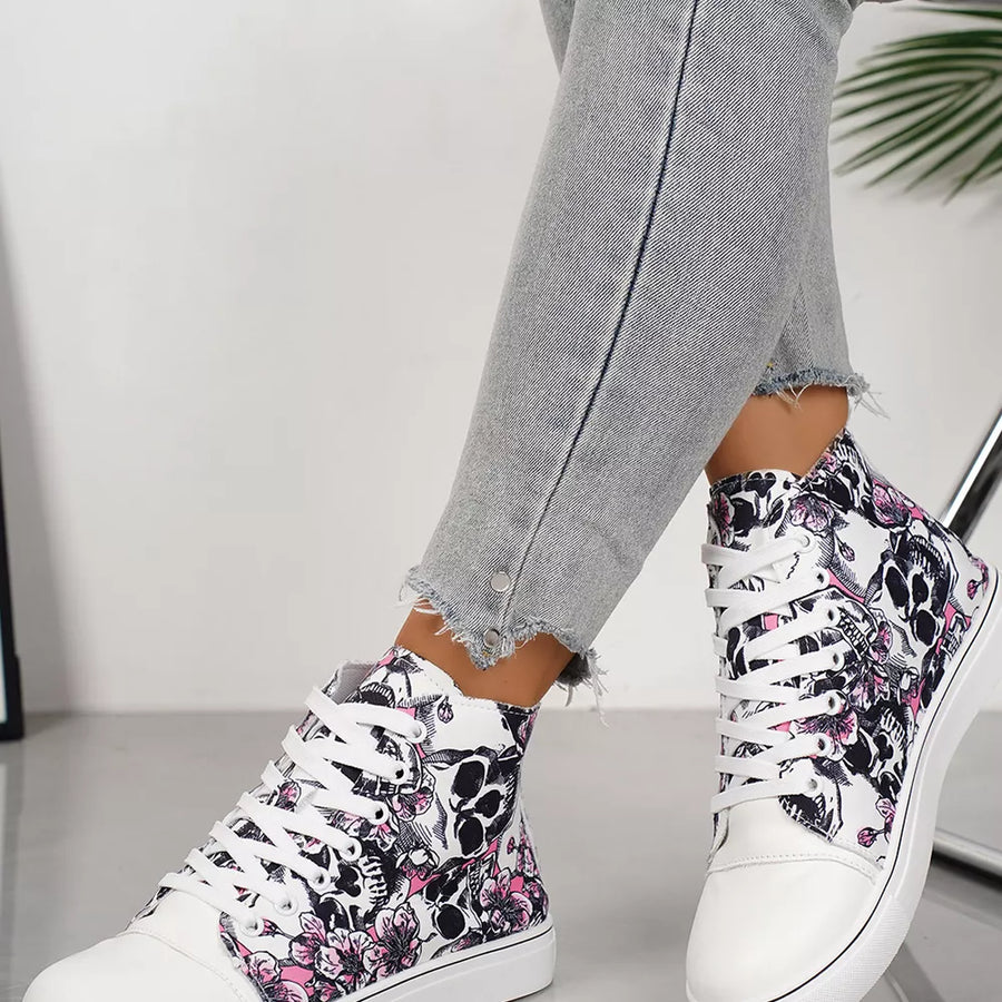 White lace-up sneakers with a black and pink floral skull print.