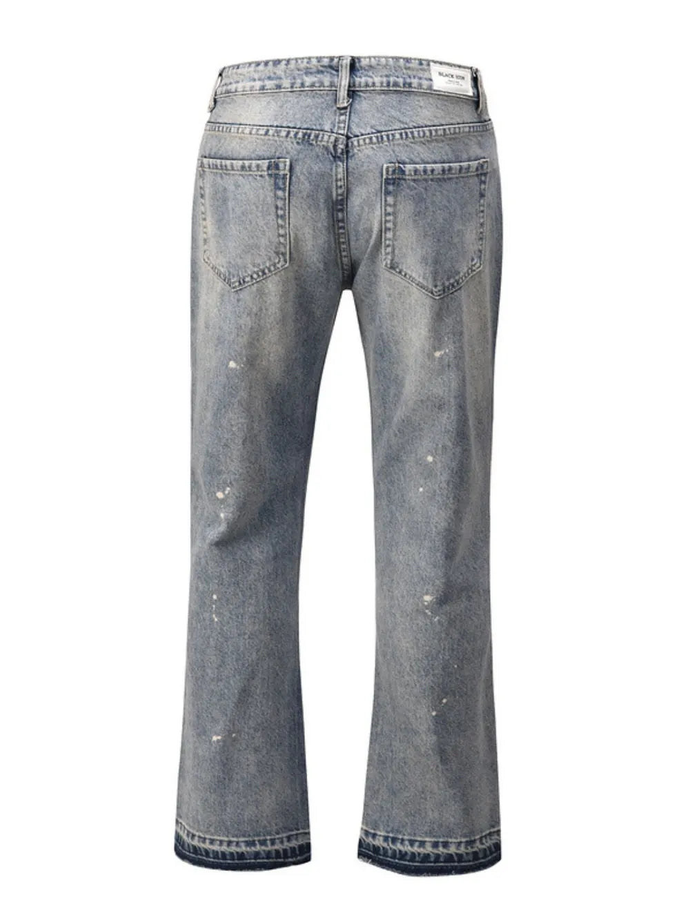 Distressed wash bootcut jeans with raw hem detail in medium blue denim.