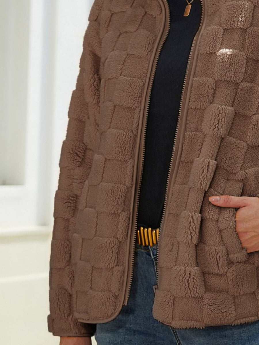 Brown textured grid zip-up jacket with a soft fleece material and a full zip closure.