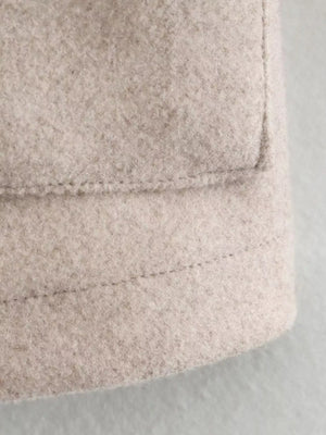 Beige trucker jacket detail showing textured fabric and stitching