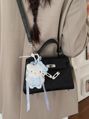 Black croc-embossed mini crossbody bag with silver hardware and a fluffy white charm.