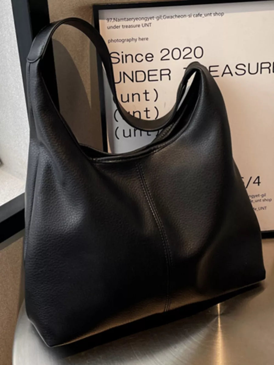 Black pebbled leather hobo shoulder bag with a slouchy silhouette and single strap.
