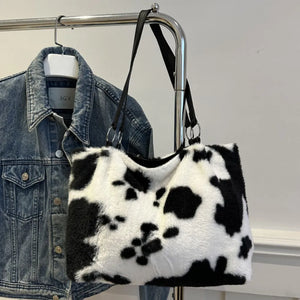 Cowhide print faux fur shopper bag with black straps and silver hardware.