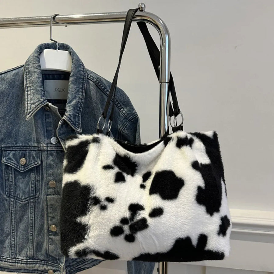 Cowhide print faux fur shopper bag with black straps and silver hardware.