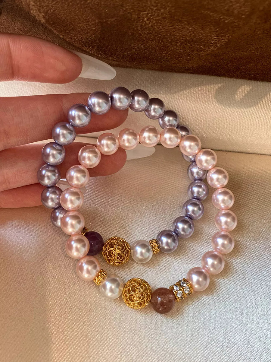 Pearl beaded bracelets with gold accents and crystal details in white, blush pink, and pink purple.